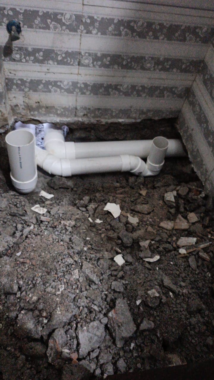 New PVC drain pipes and fittings laid in an opened-up bathroom floor