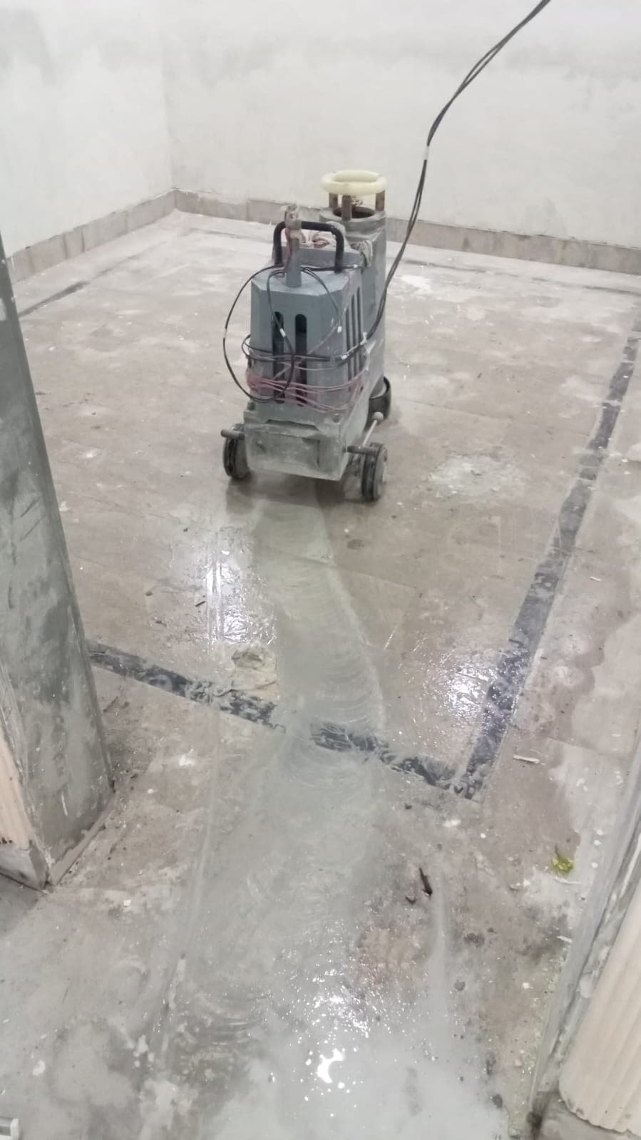 A floor polishing machine working over a marble floor with dark border strips